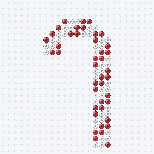 A red and white striped candy cane fuse-bead pattern with a curved hook, on a pegboard grid.