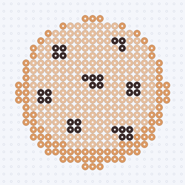 A round Sand cookie with a Butterscotch baked edge and seven Cocoa chocolate-chip clusters, on a pegboard grid.
