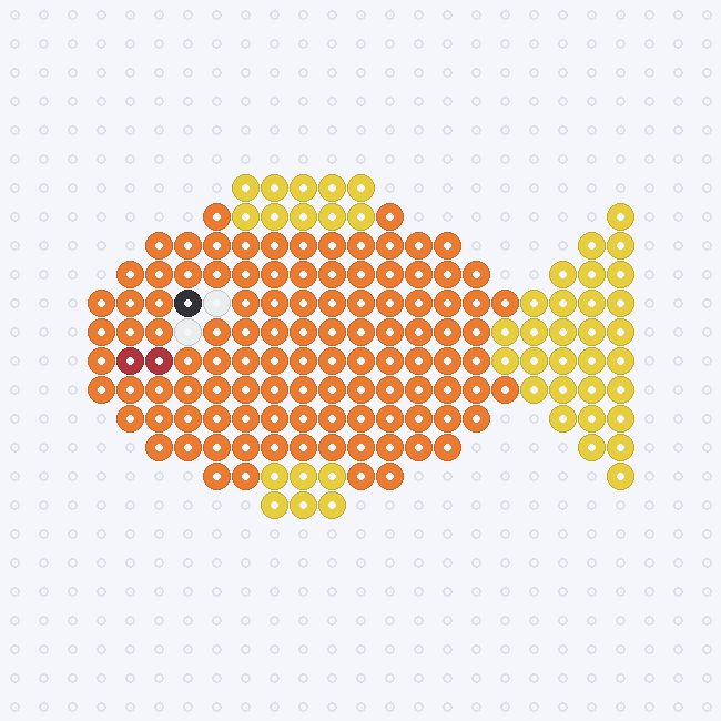 An orange fish fuse-bead pattern with yellow fins and tail, a black and white eye and a red mouth, facing left on a pegboard grid.