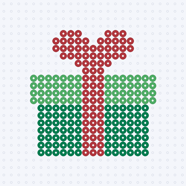 A green gift box fuse-bead pattern with a lighter green lid, a red ribbon running down the middle and a red bow on top, on a pegboard grid.