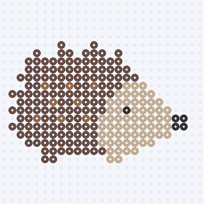 A hedgehog with a pointed Brown back, Light Brown flecks, a Tan face and a Black eye and nose, on a pegboard grid.